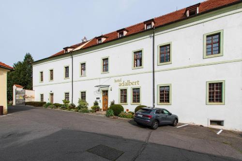 a car parked in front of a white building at Adalbert Ecohotel in Prague