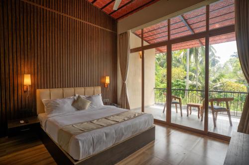 ein Schlafzimmer mit einem Bett und einem Balkon in der Unterkunft The Coral Bentley Hotels in Havelock Island