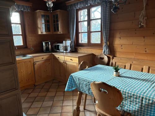 uma cozinha com uma mesa com uma toalha de mesa azul xadrez em Preisöxlhütte in Sankt Veit em Schwarzenbach