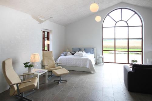 a bedroom with a bed and a table and chairs at Sellebjerg Apartment in Bindslev