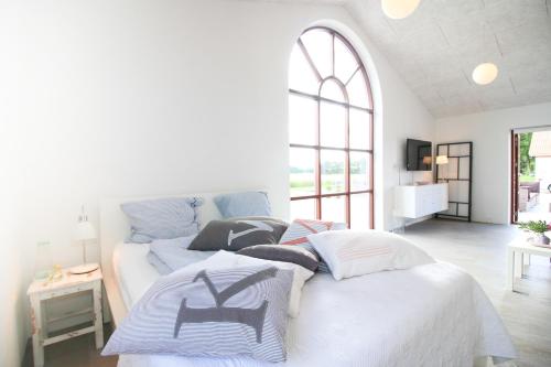 a white bedroom with a bed with pillows on it at Sellebjerg Apartment in Bindslev