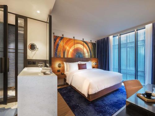 a hotel room with a bed and a desk at Pullman Budapest in Budapest