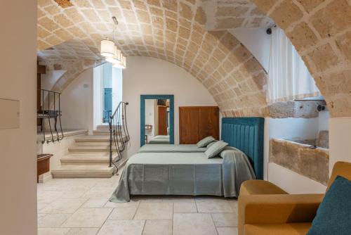 a bedroom with a bed in a room with stairs at Palazzo Arco Cadura Hotel & Spa in Galatina
