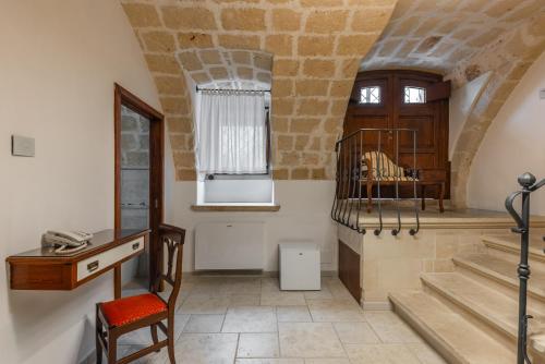a room with a desk and stairs in a building at Palazzo Arco Cadura Hotel & Spa in Galatina
