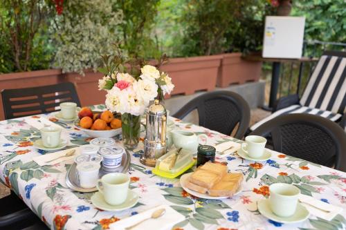 a table with a table cloth with food and flowers at Villa Nicola in Camaiore