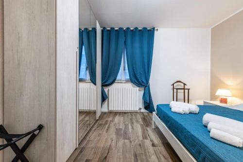 a bedroom with blue curtains and a blue bed at Giode X Veronetta in Verona