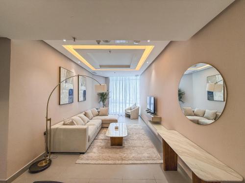 a living room with a couch and a mirror at Sedra Residence in Kuwait