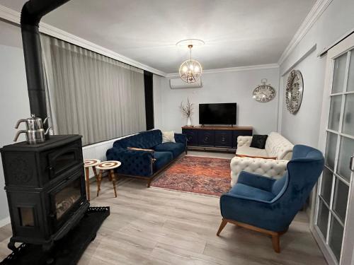 a living room with blue chairs and a fireplace at Quiet House in İznik