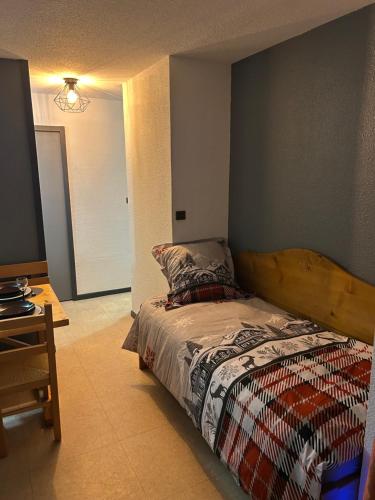 ein Schlafzimmer mit einem Bett mit hölzernem Kopfteil in der Unterkunft Appartement cosy quartier Napoléon in Val Cenis