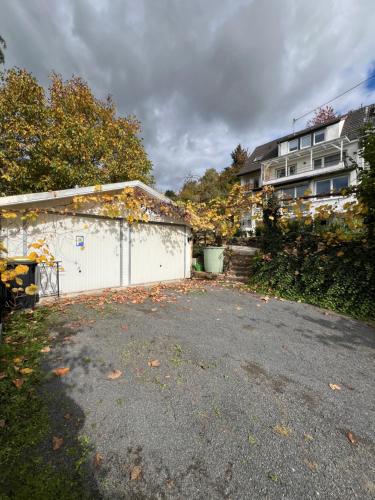 a parking lot with a white garage and a house at Wohnung mit schönem Aussicht in Bendorf
