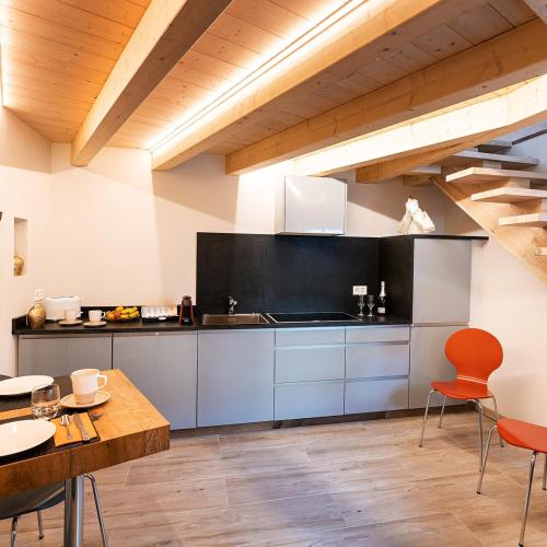 a large kitchen with a table and chairs at Bomaloft - Quiet by the River, Walk to Everything in Zermatt