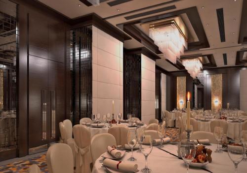 Un salón de banquetes con mesas y sillas blancas y candelabros. en Grand Canyon Hotel, en Ankara