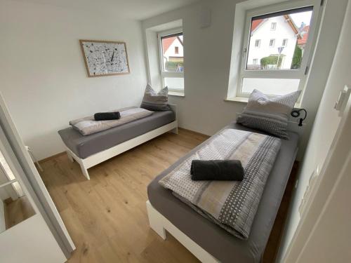 a small room with two beds and two windows at kreuzwirt bayern in Essenbach