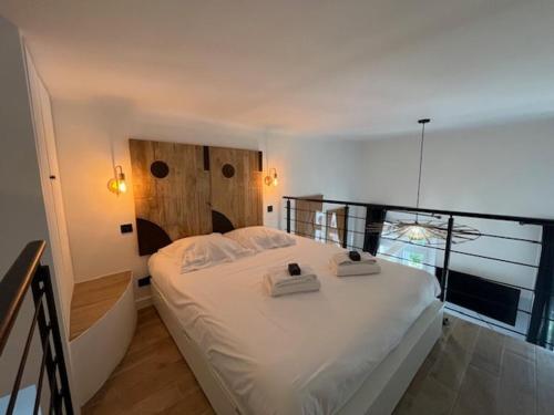 La Celle-sous-GouzonLe Bohème的卧室里有一张白色的床，床上有两条毛巾