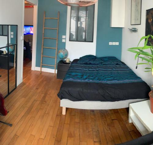 ein Schlafzimmer mit einem Bett und einem Holzboden in der Unterkunft Superbe appartement sur jardin- proche de paris in Vanves