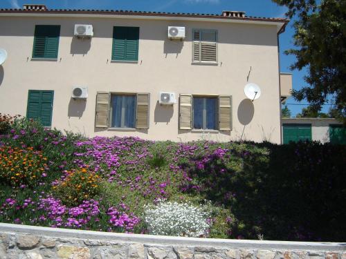 a building with flowers in front of it at Gemütliches Appartment Direkt Am Strand in Koromačno