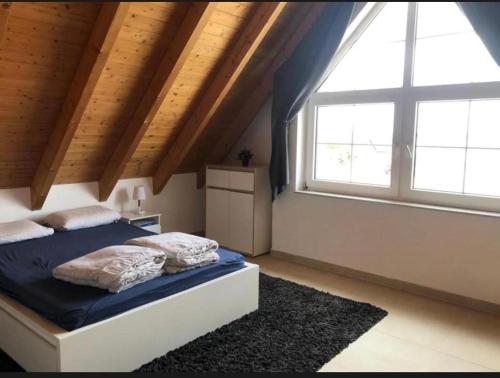 a bedroom with a bed and two large windows at City Apartments Bobenheim-Roxheim- Modern und Luxurious in Bobenheim-Roxheim