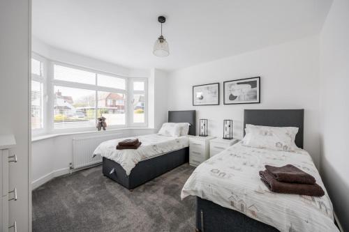 a bedroom with two beds and a window at Seaside Bungalow with Garden & Inflatable Hot Tub in Hamworthy