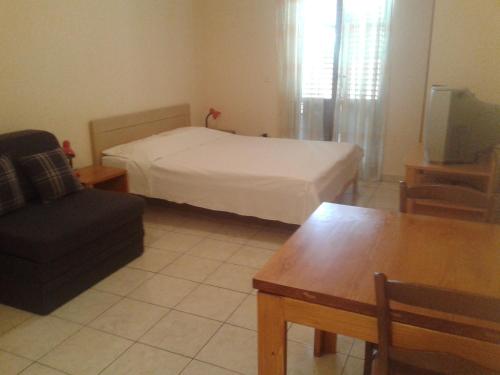 a bedroom with a bed and a couch and a table at Apartments D & P in Korčula