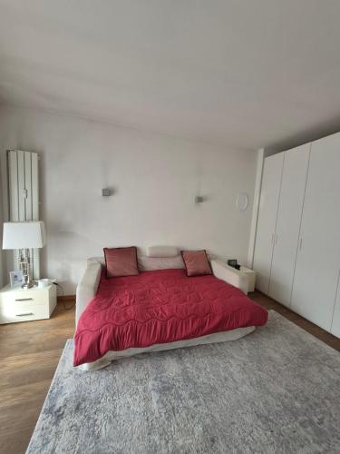 a bedroom with a bed with a red blanket at WhiteHome in Conegliano