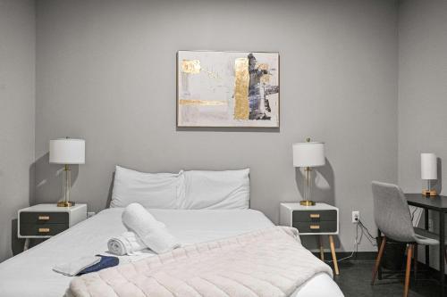 Un dormitorio con una cama y dos mesas y dos lámparas. en CozySuites Modern 1BR Downtown Pitts 10, en Pittsburgh