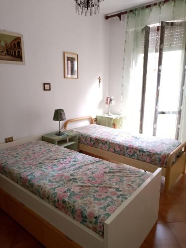 a bedroom with two beds and a window at Casafiorella in Monza
