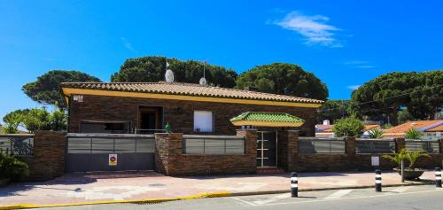 a brick house on a street with trees in the background at Villa BARLOVENTO SPA in Cambrils