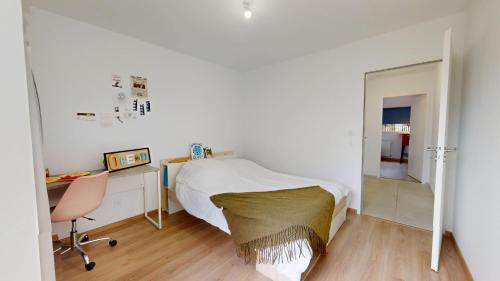 ein Schlafzimmer mit einem Bett, einem Schreibtisch und einem Stuhl in der Unterkunft Casa 3 Merlyne Plage in Saint-Gilles-Croix-de-Vie