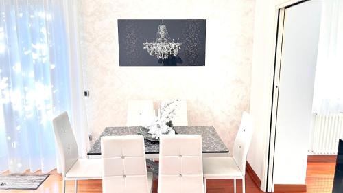 Un comedor con una mesa y sillas blancas. en Appartamento villatorretta24, en Riva del Garda