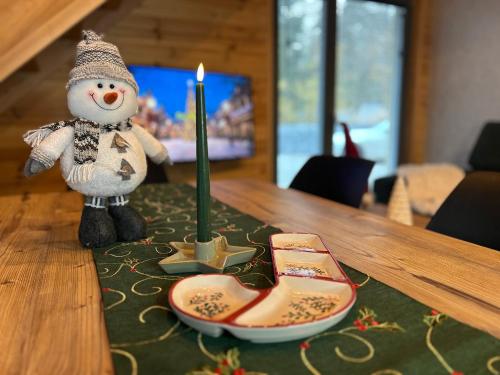 ジブヌフにあるApartamenty Naturapartのテーブルの上の雪だるまの置物とろうそく