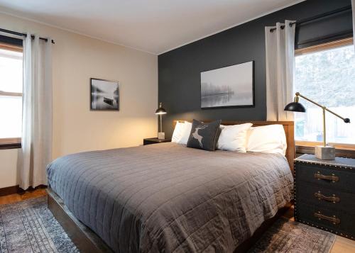 ein Schlafzimmer mit einem großen Bett und zwei Fenstern in der Unterkunft The 3 Bears Cottage - Exquisite lake views! in Duluth