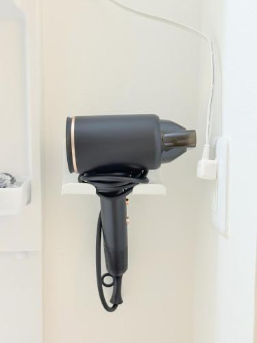 a black hair dryer hanging on a wall at Osaka Large House 13Guests 5BR 3Bath 3Shower in Osaka