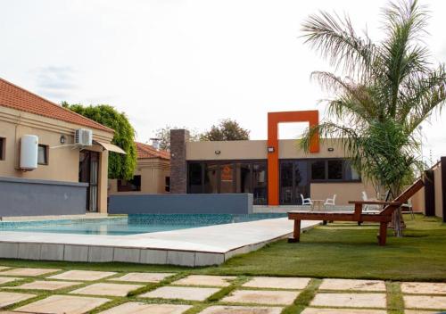 a villa with a swimming pool in front of a house at Fanky Hotel in Palatswe