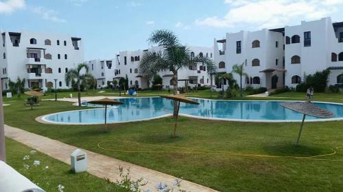 a swimming pool in front of a building at Appartement B-23 Cabo Négro in Cabo Negro