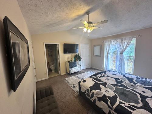 une chambre avec un lit et un ventilateur de plafond dans l'établissement Peaceful Oasis In Stonecrest, à Fairington