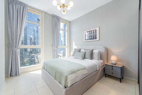 a white bedroom with a bed and a window at Urban Chic - Mangrove Place in Abu Dhabi