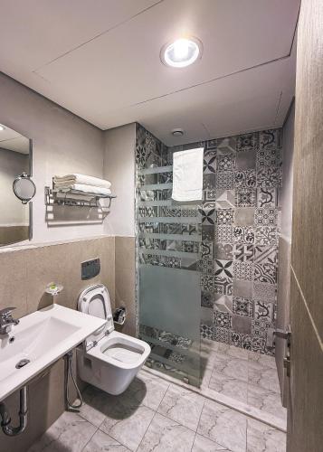 ein Badezimmer mit Dusche, Toilette und Waschbecken in der Unterkunft Sedra Residence in Kuwait