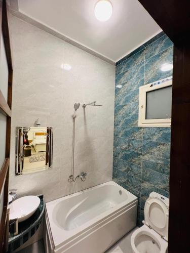a bathroom with a tub and a toilet and a sink at Twins Villa Luxor in Luxor