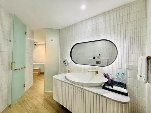 un baño con lavabo y espejo en EXCOTEL Design Hotel Surabaya, en Surabaya