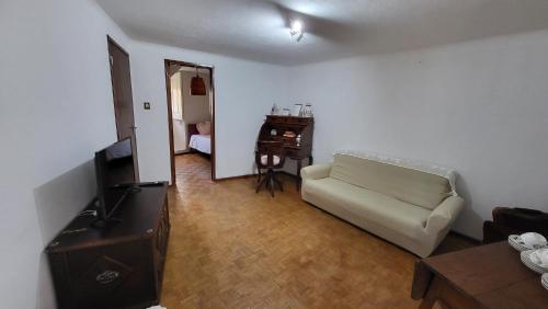 un salon avec un canapé et une télévision dans l'établissement Casa de Unhais da Serra, à Unhais da Serra