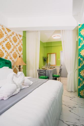 a bedroom with a bed and a dining room at The Stackey Hotel in Olongapo