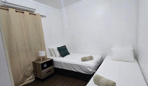 a bedroom with two beds and a night stand with a bed sqor at Cosy Homes in Suva - 2BR Family Unit in Suva