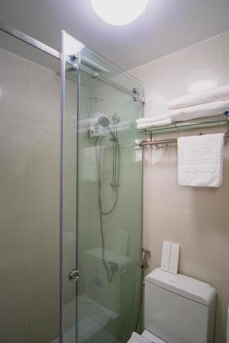 a bathroom with a glass shower with a toilet at The Stackey Hotel in Olongapo