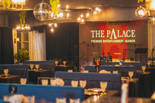 a restaurant with tables and chairs and a sign that reads the palace at The Stackey Hotel in Olongapo