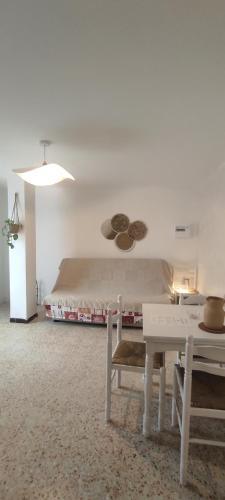 Un dormitorio blanco con una cama y una mesa. en Le laurier, en Bourg-Saint-Andéol