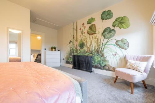 a bedroom with a painting of plants on the wall at Battersea Boutique Apartments in Bangor