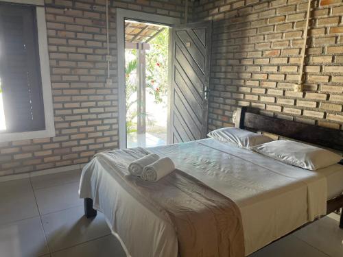 a bedroom with a bed with two towels on it at Nordestino in Pipa