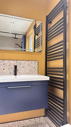 a bathroom with a sink and a mirror at Battersea Boutique Apartments in Bangor