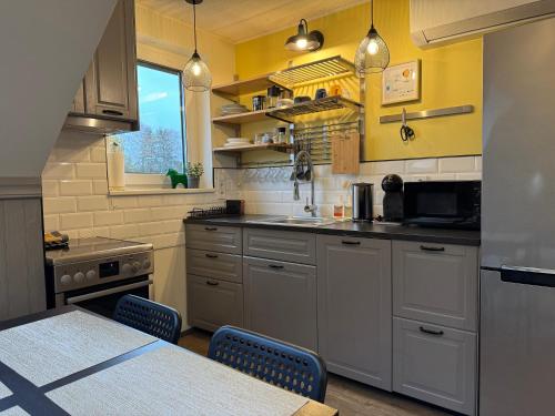 een keuken met witte kasten en een tafel met stoelen bij Penthouse in Kohila in Kohila