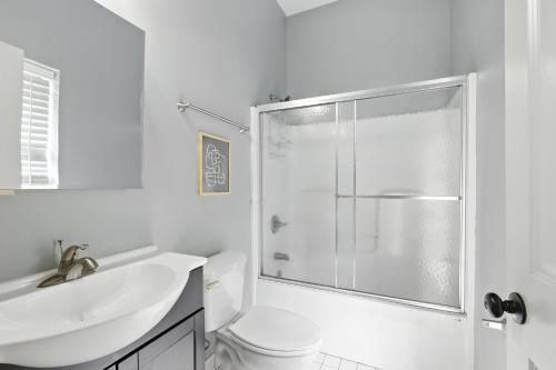 a white bathroom with a shower and a sink at New Listing Bulldog Borough in Downtown Athens in Athens